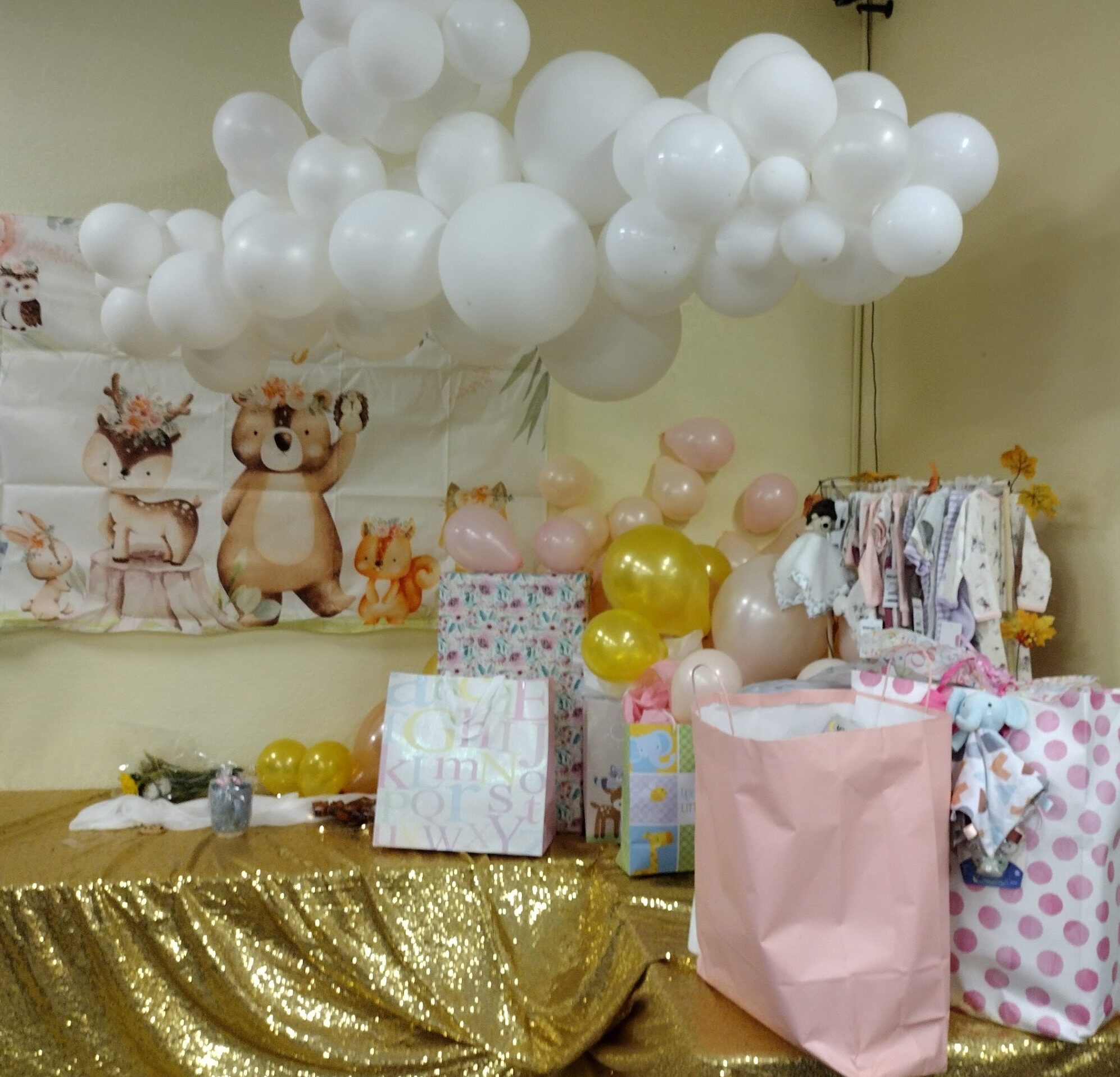 Hanging balloon cloud over gift table for baby shower