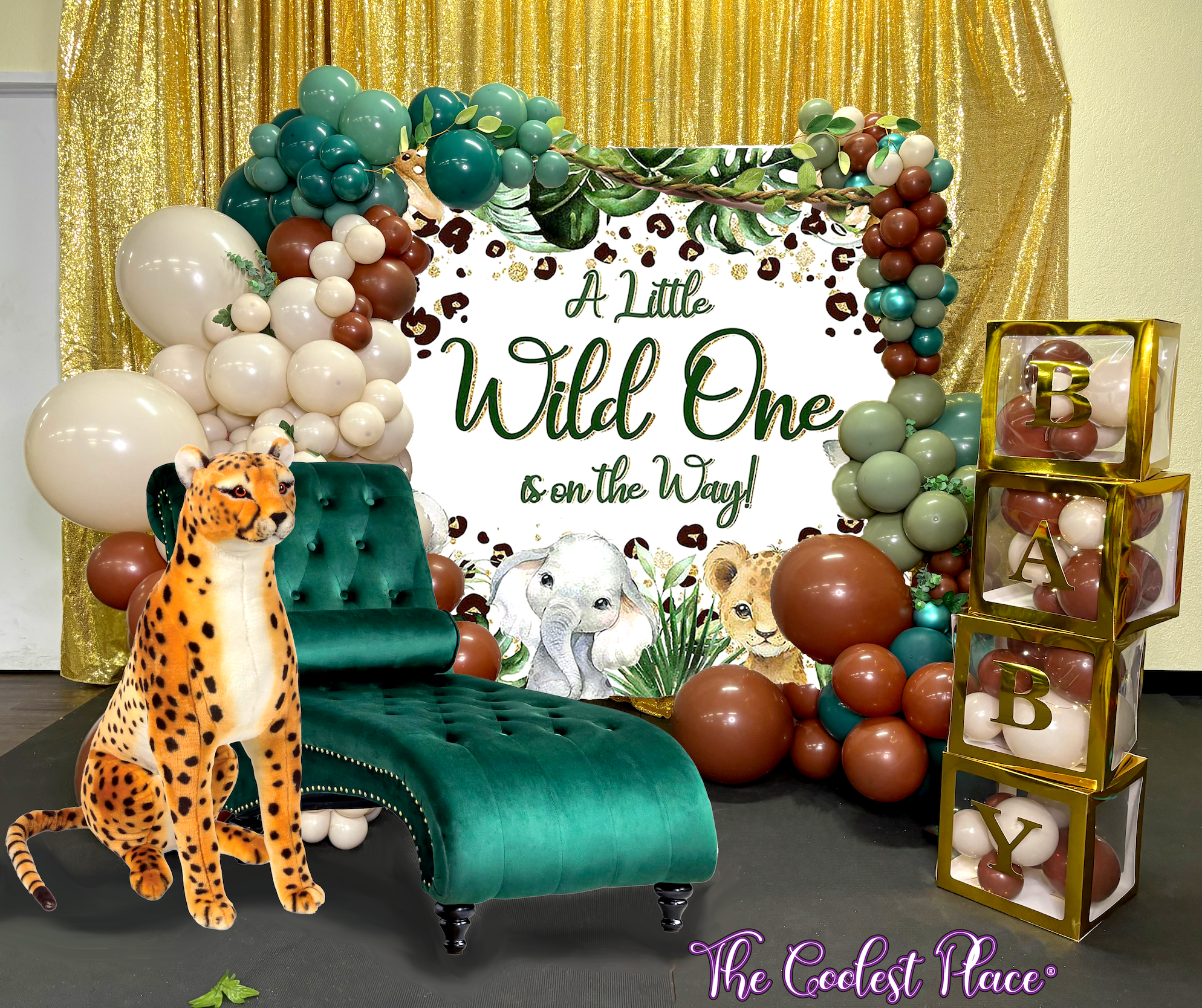 baby shower backdrop a little wild one is on the way with cheetah, balloon arrangement in brown, sand and green with baby balloon boxes and chaise lounge